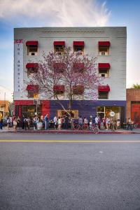 a building with a flowering tree in front of it at American Hotel in Los Angeles
