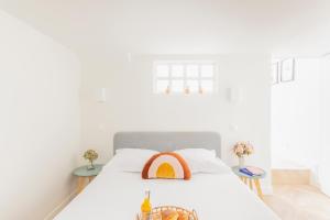 a white bedroom with a bed with two tables at CMG Cherche Midi - Sèvres in Paris