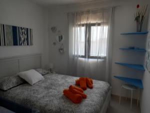 a bedroom with a bed with orange towels on it at Las Islas Apartment in Corralejo
