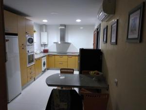 a kitchen with a table and a kitchen with yellow cabinets at Habitacion en casa particular con vista al mar in Cala del Moral