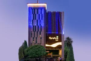 un bâtiment avec des lumières bleues sur son côté dans l'établissement Symphony Inn, à Vellore