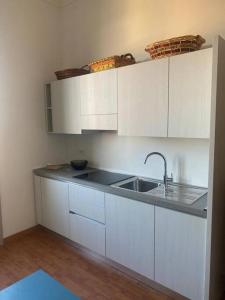 kuchnia z białymi szafkami i zlewem w obiekcie Gambara Apartment w Mediolanie