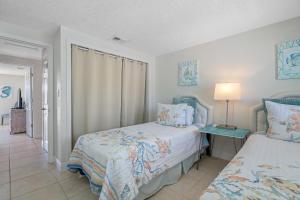 a bedroom with two beds and a lamp on a table at Stunning Waterfront Pool Home Walk to Beach & Restaurants Large Private Pool in Clearwater Beach