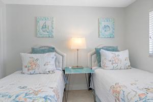 a bedroom with two beds and a table with a lamp at Stunning Waterfront Pool Home Walk to Beach & Restaurants Large Private Pool in Clearwater Beach
