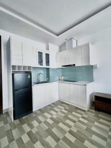ハイフォンにあるMinh Anh Hotel & Apartmentの白いキャビネットと黒い食器洗い機付きのキッチンが備わります。