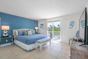 a blue bedroom with a bed and a balcony at Stunning Waterfront Pool Home Walk to Beach & Restaurants Large Private Pool in Clearwater Beach