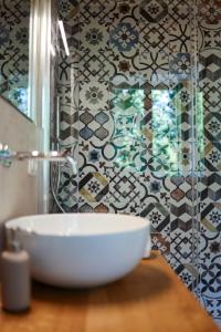 a bathroom with a sink and a tile wall at B&B CA PANISACCO in Valdagno