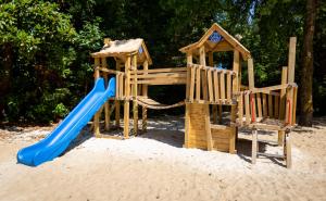 a wooden playground with a slide and a playset at Camping L'Etang D'Ardy *** in Saint-Paul-lès-Dax