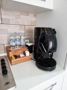 a black mixer on a counter with bottles of water at La vecchia sartoria in Mazzarino +4 photos