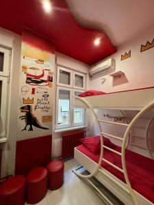 een kamer met een stapelbed met rode muren bij Pop Art in Belgrado