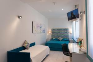 ein kleines Zimmer mit einem Bett und einem Sofa in der Unterkunft Hotel Panorama in Maiori