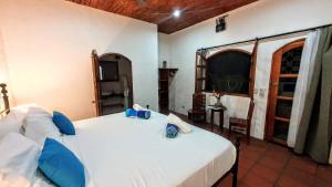 a bedroom with a large white bed with blue pillows at Boutique Hotel Secret Garden Granada in Granada