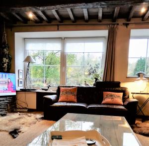 a living room with a couch and a table at Bouillon, au faubourg de France, face à la Semois GRAND RAID 26 LES 12 ET 13 SEPTEMBRE 26 in Bouillon