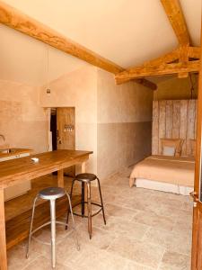 サン・サテュルナン・ダプトにあるLe Vieux Portailのテーブル、スツール2脚、ベッド1台が備わる客室です。