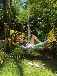 a woman laying in a hammock in the grass at Green View Safari Resort in Udawalawe