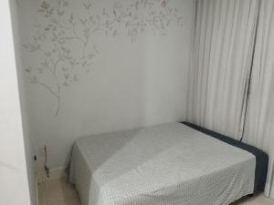1 dormitorio con 1 cama y pared con un mural de árboles en Flat Aconchegante na Asa Sul, en Brasilia