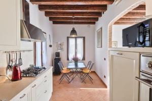 a kitchen with a table and chairs in a kitchen at Villa Navagero - Ca' degli Stefani C in Rovarè
