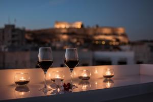 dos copas de vino sentadas en una mesa con velas en Acropolis Select, en Atenas