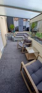 a patio with chairs and couches on a balcony at La maison d hôte d emmanuelle in Saint-Antoine-la-Forêt