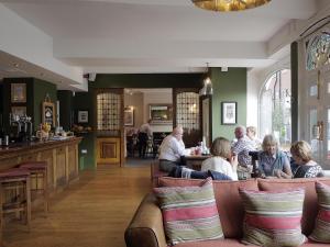 a group of people sitting at a bar in a restaurant at The Rose and Crown in Warwick