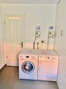 a washer and dryer in a room with a door at Bummert Am Hafen 2 Greetsiel in Krummhörn