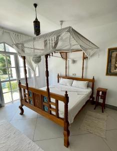 1 cama con dosel en una habitación en Ground floor apartment Simba Village, Diani, en Ukunda