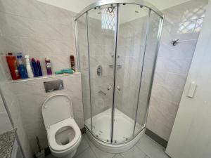 y baño con ducha y aseo. en Ground floor apartment Simba Village, Diani, en Ukunda