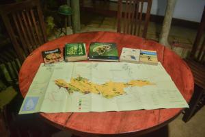 a wooden table with a map and books on it at Nature Trails Lodge - Sinharaja in Deniyaya