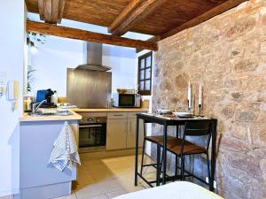 eine Küche mit einer Theke und einem Tisch in einem Zimmer in der Unterkunft Le petit Châtaignier - Cozy Immo in Châtenois