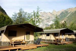 um grupo de tendas com montanhas ao fundo em Camping RCN Belledonne em Le Bourg-dʼOisans