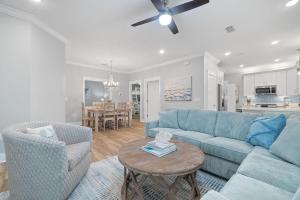 sala de estar con sofá azul, sillas y mesa en Barefoot Bungalow at Rookery, en Gulf Shores