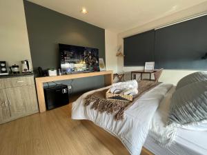 um quarto com uma cama e uma televisão de ecrã plano em The UpperRoom @ Real Suites em Bacolod