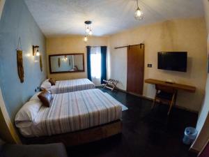 a hotel room with two beds and a television at relax hotelito in Cárdenas