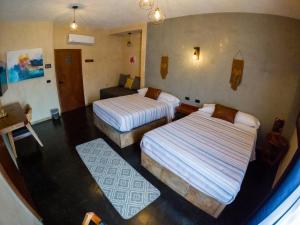 a room with two beds and two rugs at relax hotelito in Cárdenas