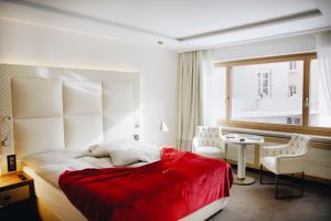 1 dormitorio con cama, mesa y ventana en Hotel Arte en St. Moritz