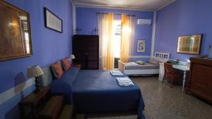 een slaapkamer met blauwe muren en een bed en een bureau bij Il Genio del Porto - Mabbonath b&b in Palermo