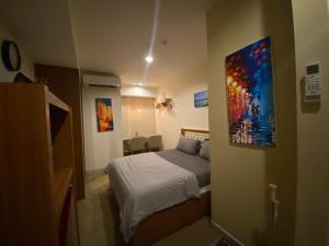 um quarto com uma cama e um quadro na parede em Grand Kamala Lagoon By Paris Properti em Rawapanjang