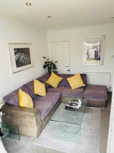 a living room with a purple couch with yellow pillows at Arma Short Stays 122 - Spacious 3 Bed Oxford House Sleeps 6- FREE PARKNG For 2 Vehicles - Large Garden in Oxford