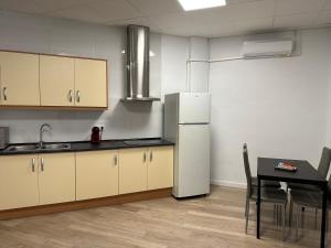 a kitchen with a white refrigerator and a table at Apartamento tipo loft valencia in Paiporta
