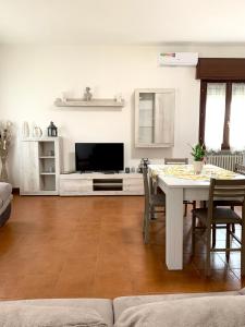 sala de estar con mesa y TV en La Cicala - appartamento con giardino privato, en Rivoli Veronese