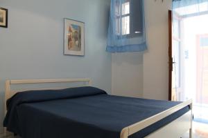 1 dormitorio con cama con sábanas azules y ventana en Appartamenti Stella en Lipari