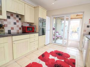 a kitchen with a red flower rug on the floor at Brewers House in Weymouth