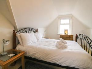 a bedroom with a bed with white sheets and a window at Brewers House in Weymouth