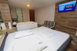 een kamer met een bed en een tv aan de muur bij Eden Hotel (Adults Only) in Rio de Janeiro