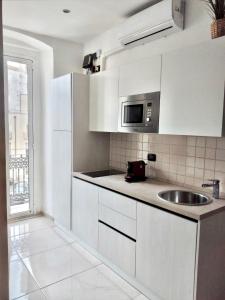 a white kitchen with a sink and a microwave at B&B Romeo in Bari