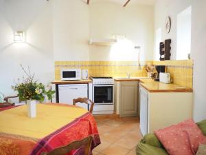 una pequeña cocina con mesa y microondas en Nice provençal holiday home with garden and pool, Mollans-sur-Ouvèze, en Mollans-sur-Ouvèze