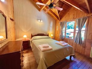 a bedroom with a bed with two towels on it at Villa Cümen in San Martín de los Andes