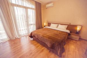 a bedroom with a bed and a large window at Royal Venezia Hotel in Batumi