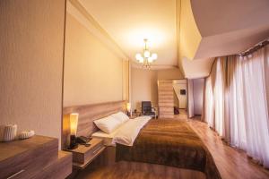 Habitación de hotel con cama y escritorio en Royal Venezia Hotel, en Batumi