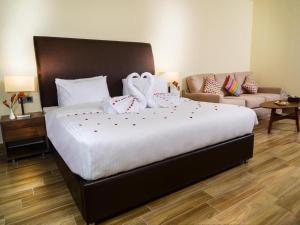 a bedroom with a large bed and a couch at Masaya By Emerald in Erbil